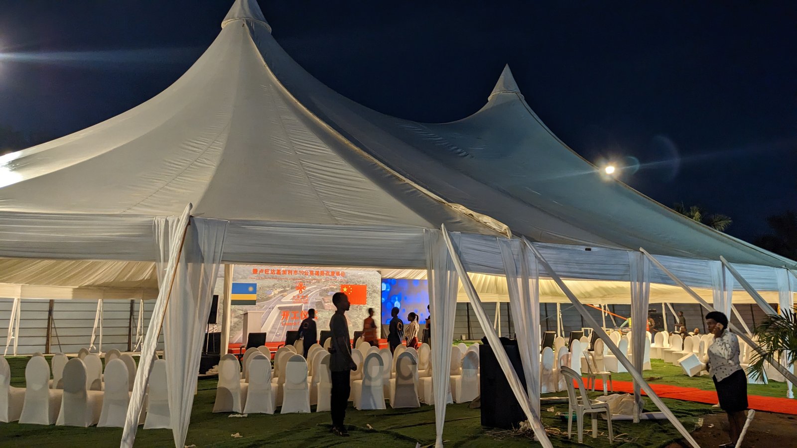 Exterior view of double-peak marquee tent setup for road construction ceremony in Masaka, Kigali